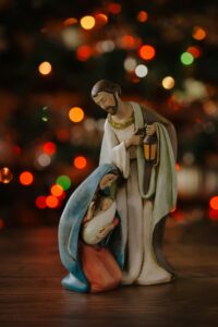 Close-up of Nativity figurines with colorful bokeh lighting, capturing the essence of Christmas.