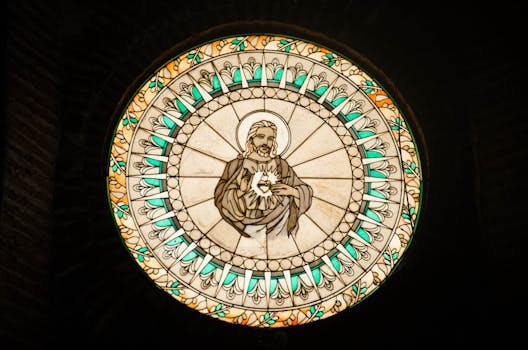 Circular stained glass window illustrating Jesus Christ, a serene religious artwork.